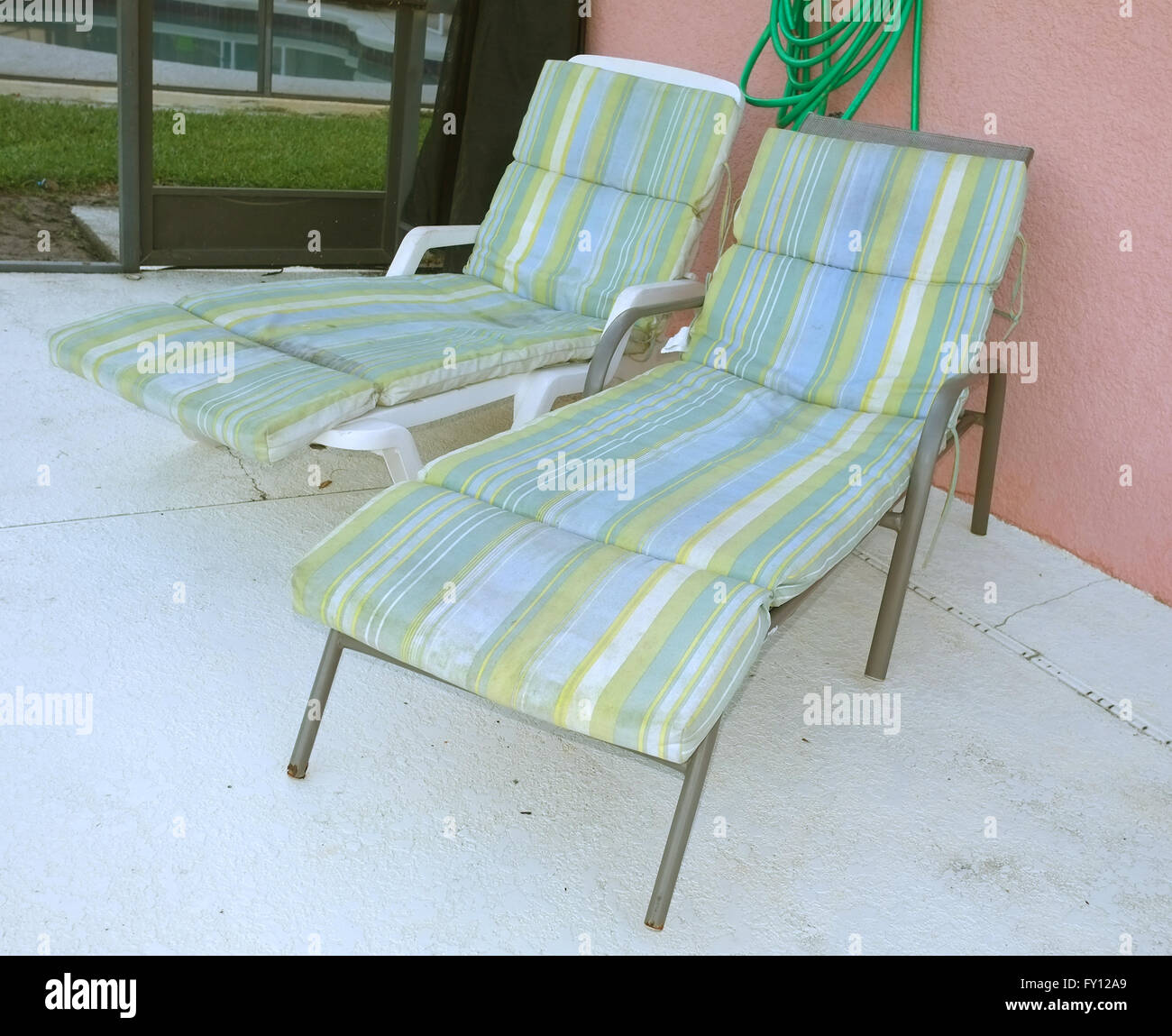 Coppia dispari della vecchia estate sedie a sdraio al di fuori di un affitto villa Florida, Aprile 2016 Foto Stock