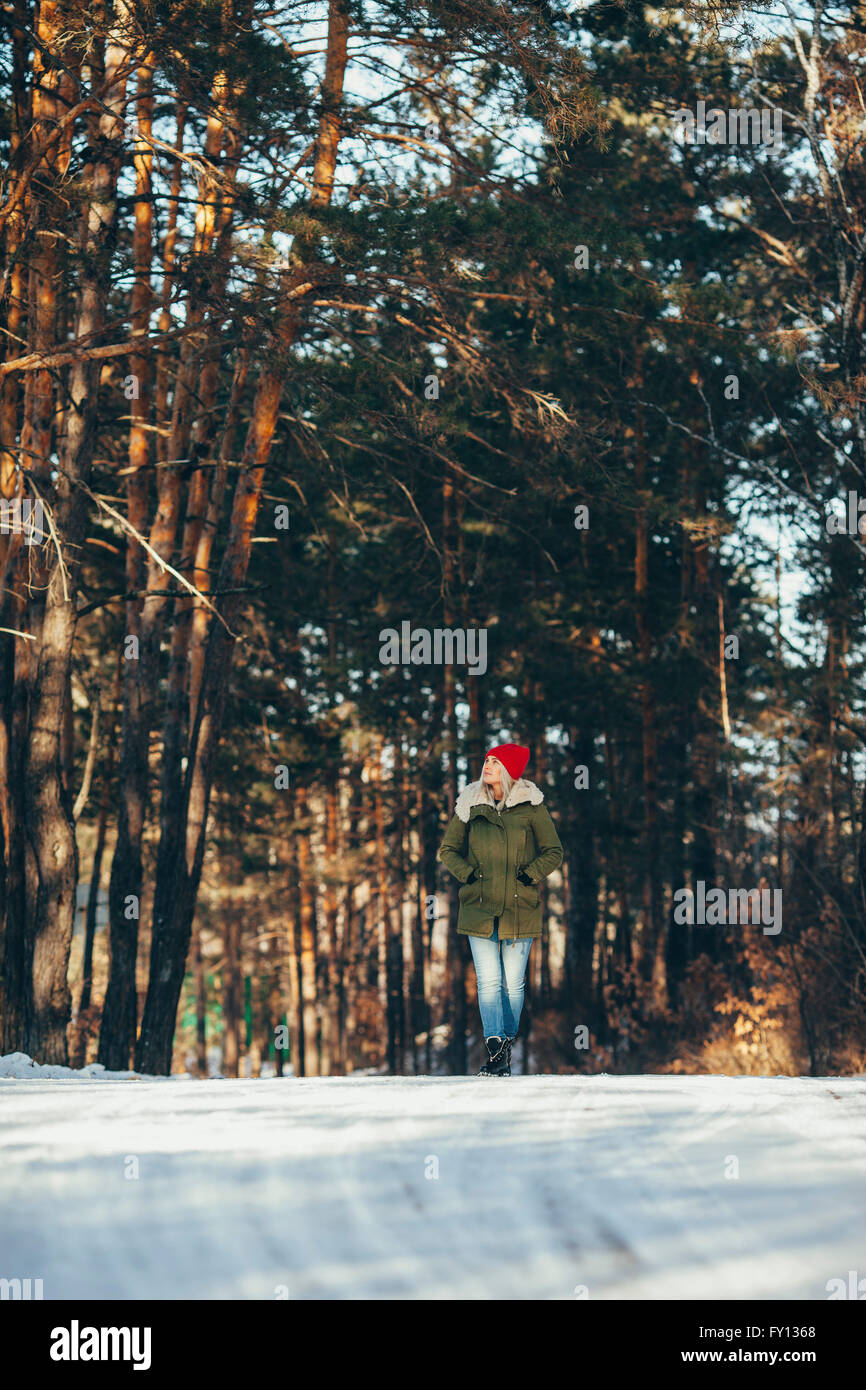 Per tutta la lunghezza della donna a piedi nella neve coperto foresta Foto Stock