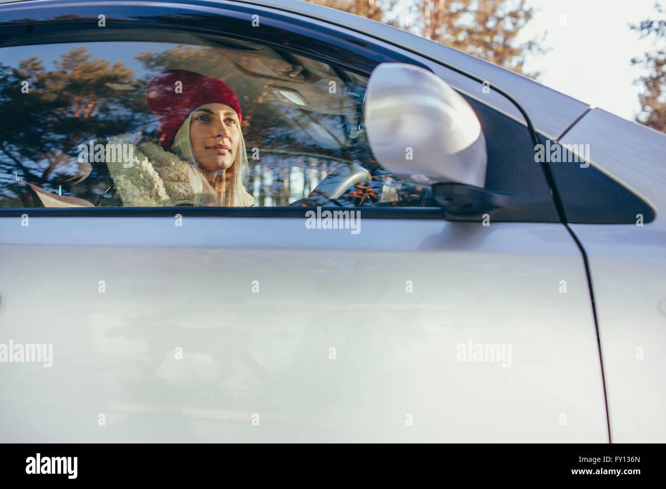 Basso angolo di visione della donna alla guida di auto durante il periodo invernale Foto Stock