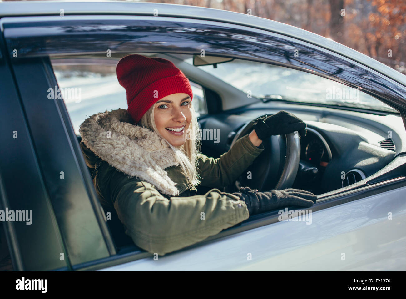 Ritratto di felice bella donna alla guida di auto durante il periodo invernale Foto Stock
