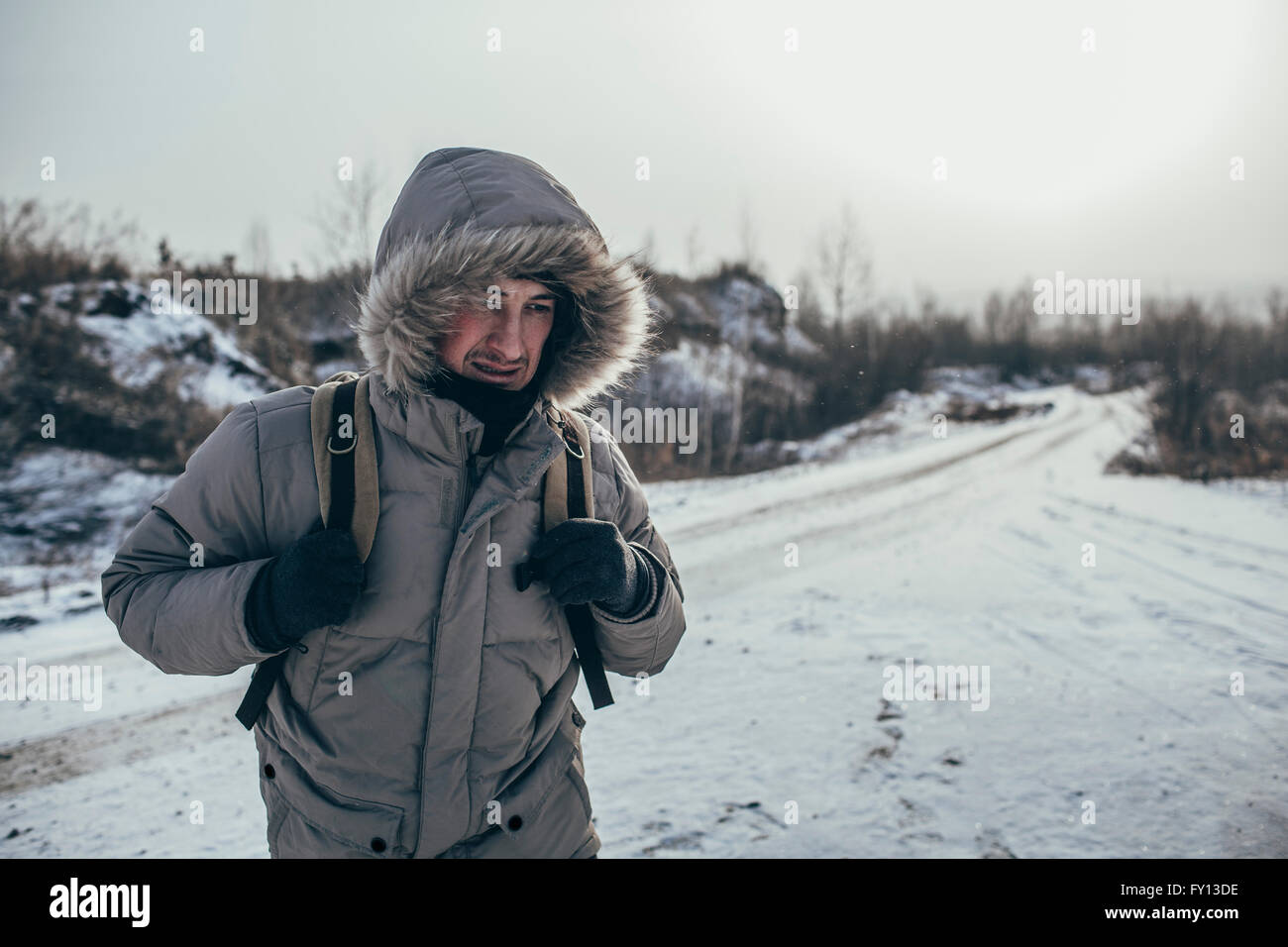 Escursionista che porta uno zaino mentre in piedi su paesaggi innevati Foto Stock