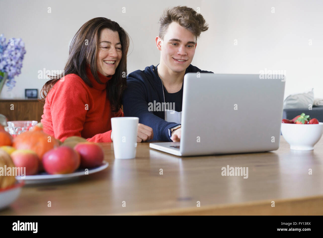 Felice madre e figlio utilizzando computer portatile sul tavolo a casa Foto Stock