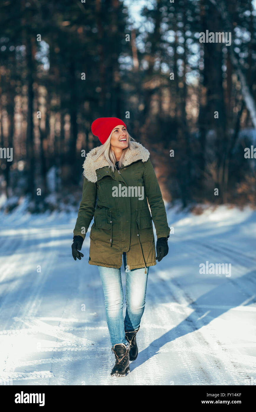 Per tutta la lunghezza della donna felice passeggiate sulla neve campo coperto Foto Stock