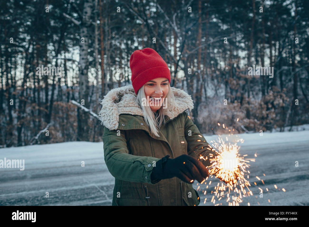 Donna felice azienda botti mentre si sta in piedi sul campo durante il periodo invernale Foto Stock