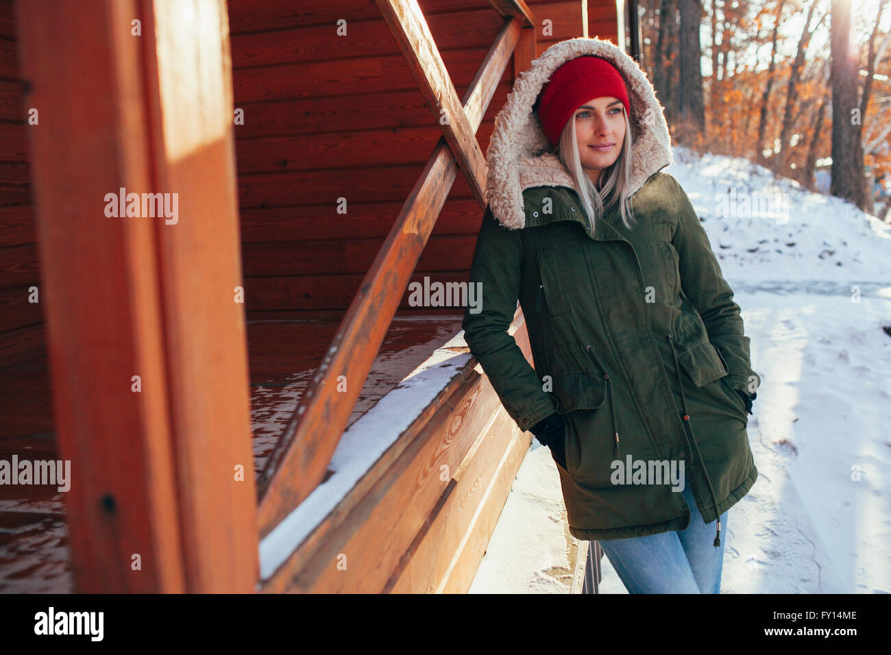 Giovane donna che guarda lontano mentre appoggiata sulla cabina Foto Stock