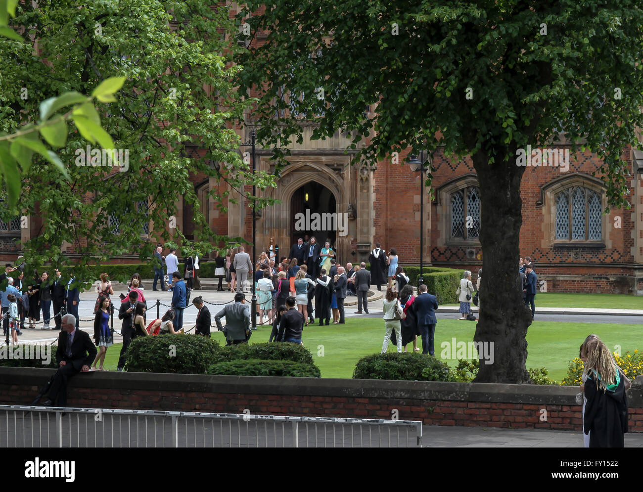 Gli studenti e le loro famiglie ad una università del Regno Unito il giorno di graduazione al di fuori dell'edificio Lanyon al Queens University di Belfast. Foto Stock