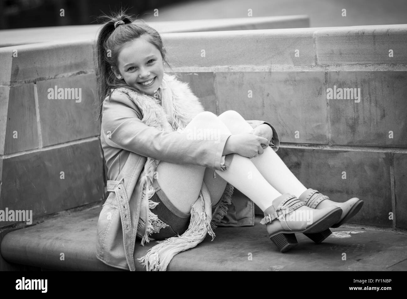 Giovane ragazza piuttosto che pongono all'esterno in una posizione urbana, Leeds, West Yorkshire, Inghilterra. Foto Stock