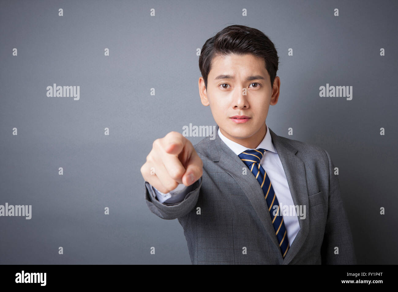 Ritratto di giovane imprenditore rivolta verso la parte anteriore con un cipiglio sul suo volto a fissare i parte anteriore Foto Stock