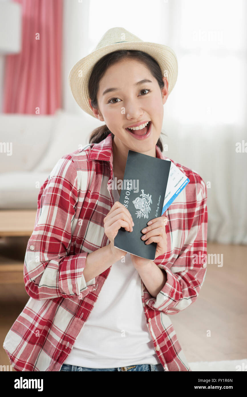 Giovane donna sorridente in posa con biglietto aereo Foto Stock