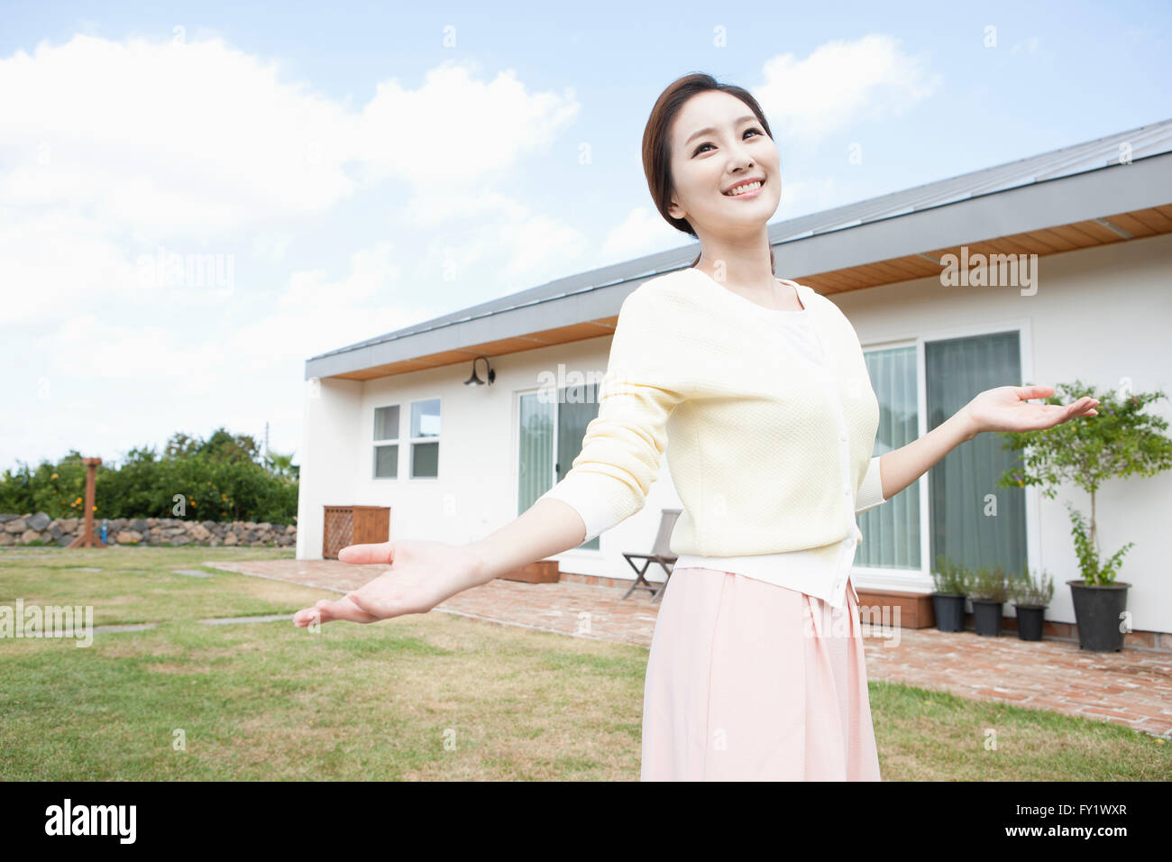 Donna con le braccia aperte al cantiere di una casa che rappresentano la vita rurale Foto Stock