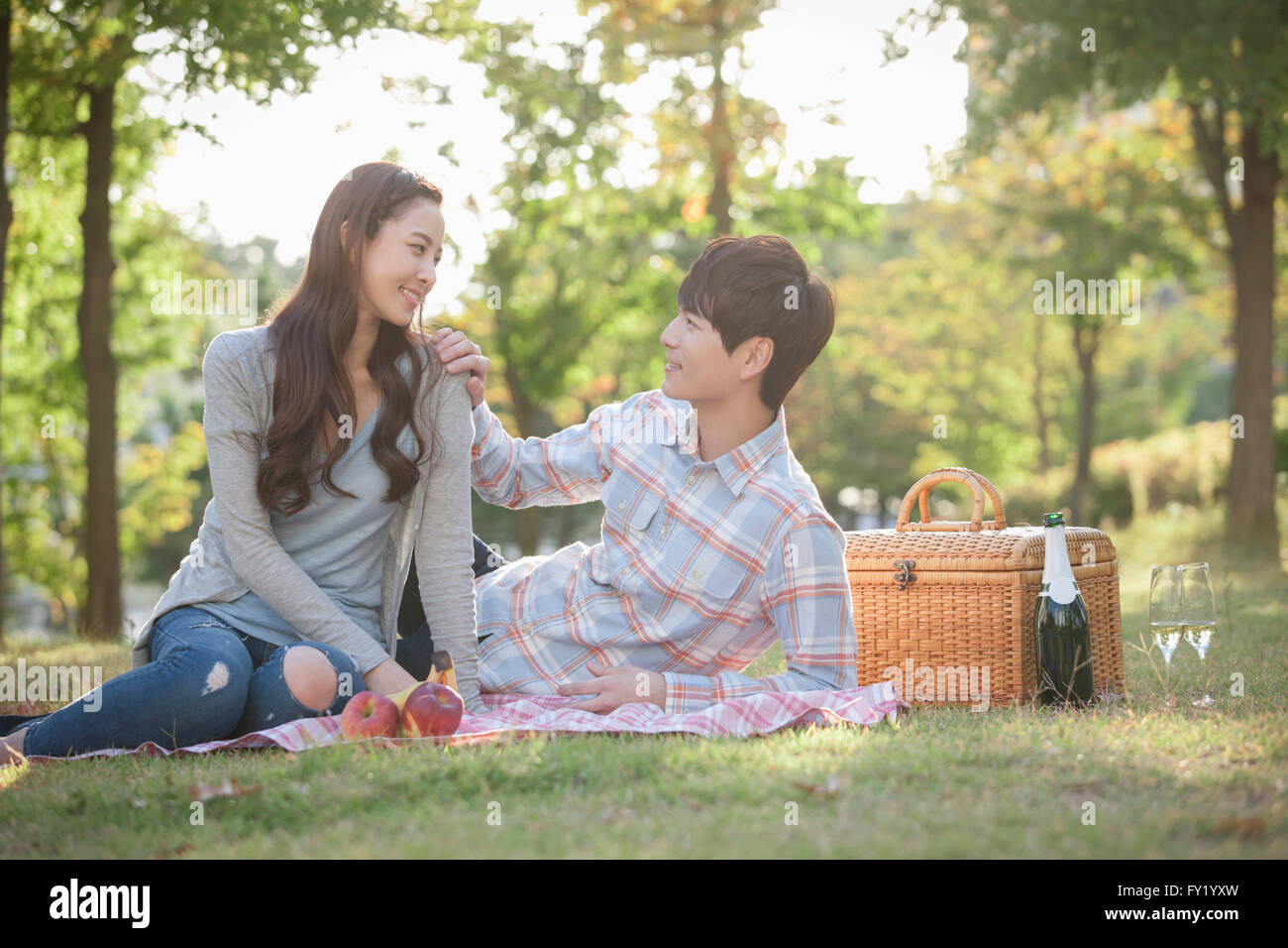 Giovane su un picnic e guardando a vicenda con un sorriso a park Foto Stock