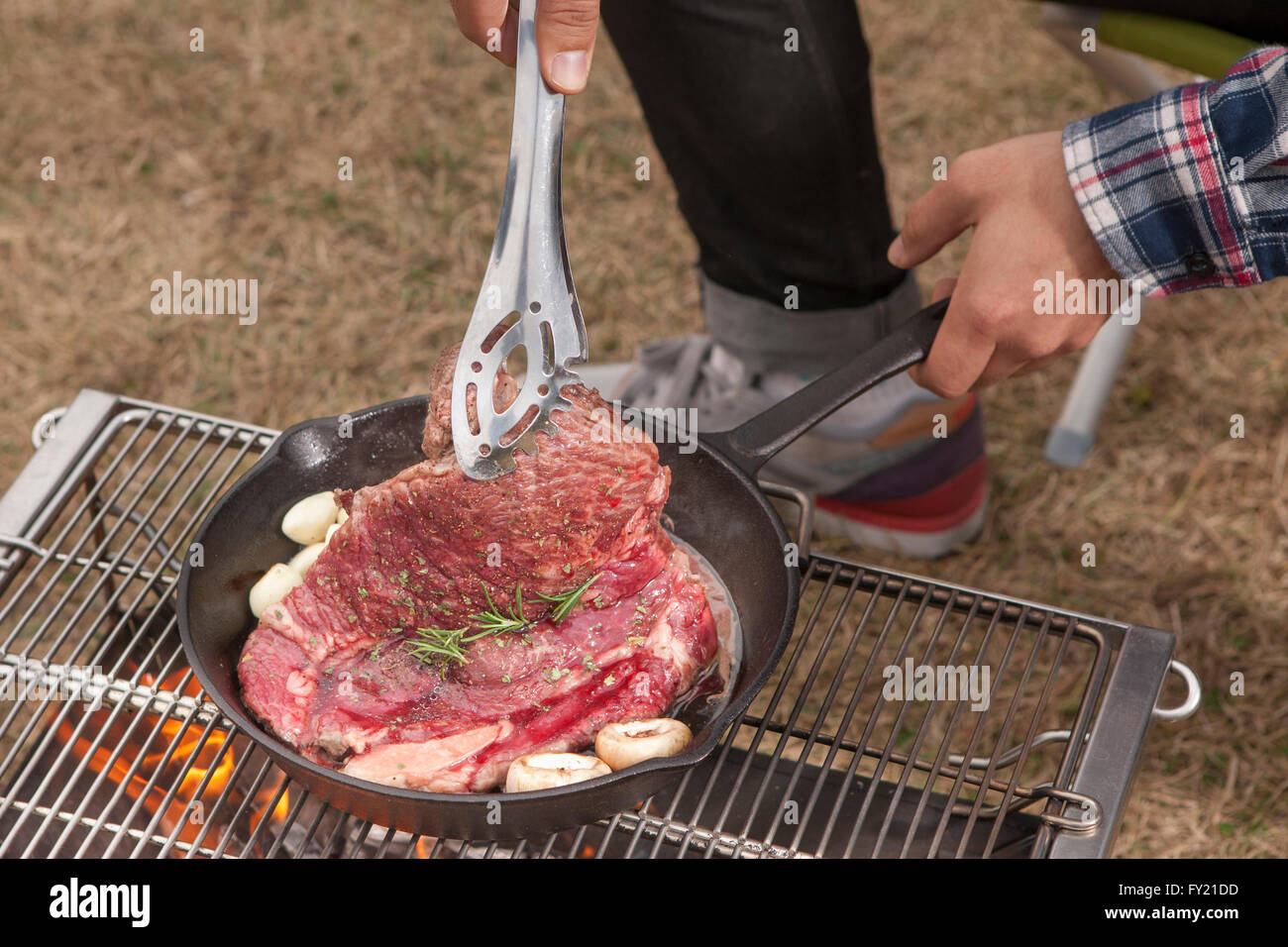Bistecca di essere cucinati da una persona Foto Stock