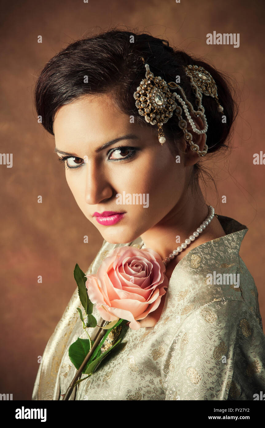 Bella donna asiatica con una rosa rosa Foto Stock