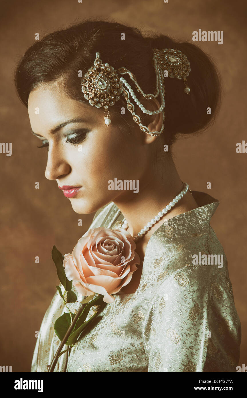 Bella donna asiatica con una rosa rosa Foto Stock