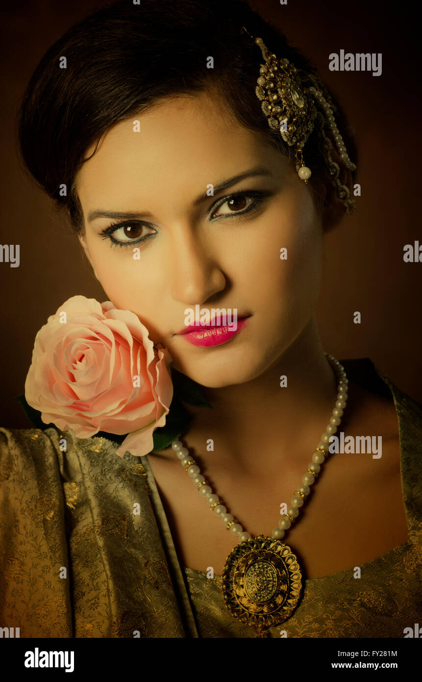 Bella donna asiatica con una rosa rosa Foto Stock