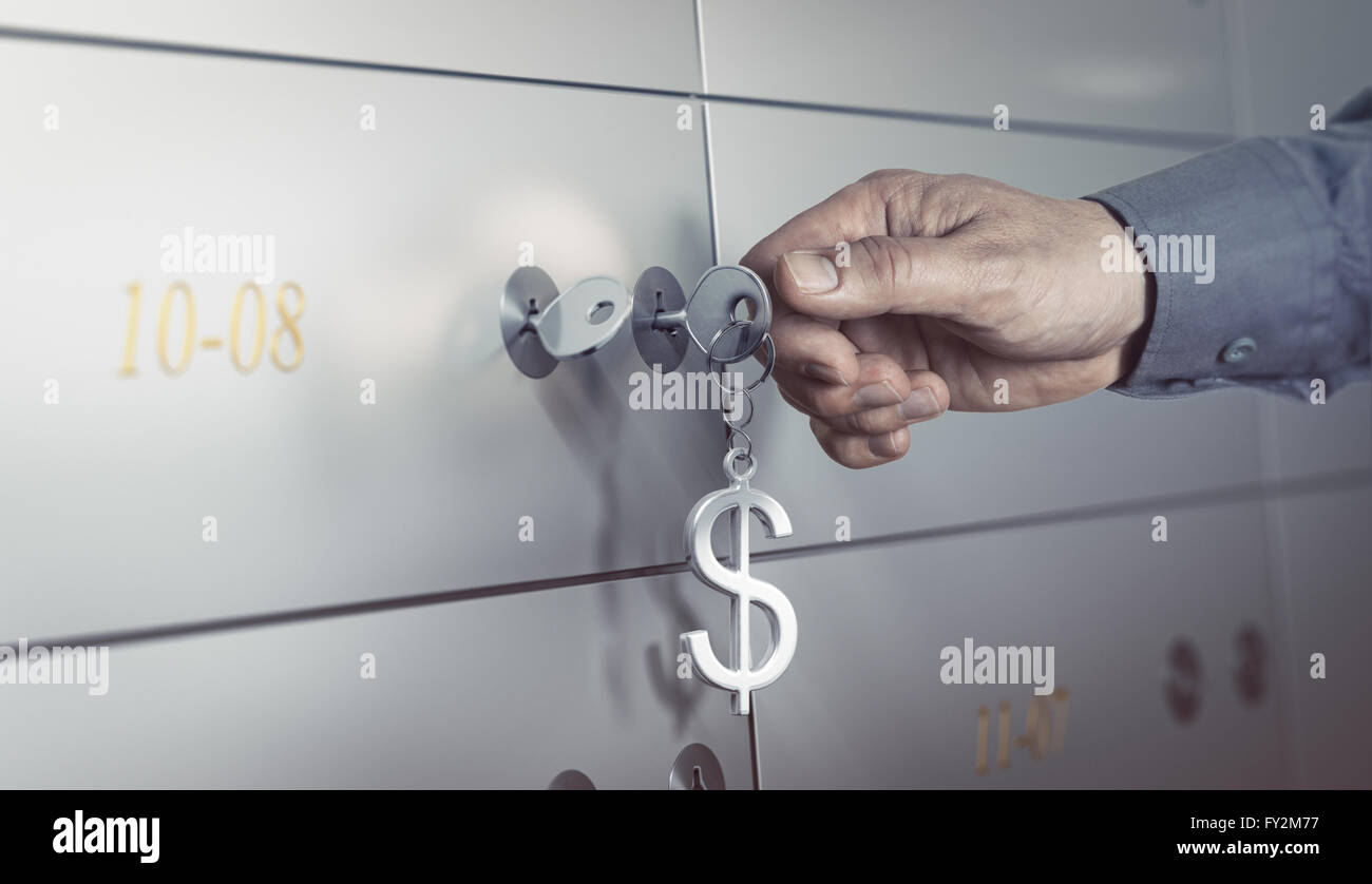 La cassetta di sicurezza in un caveau della banca, mano circa a sua volta una chiave per aprire una cassetta di sicurezza. concetto finanziario Foto Stock