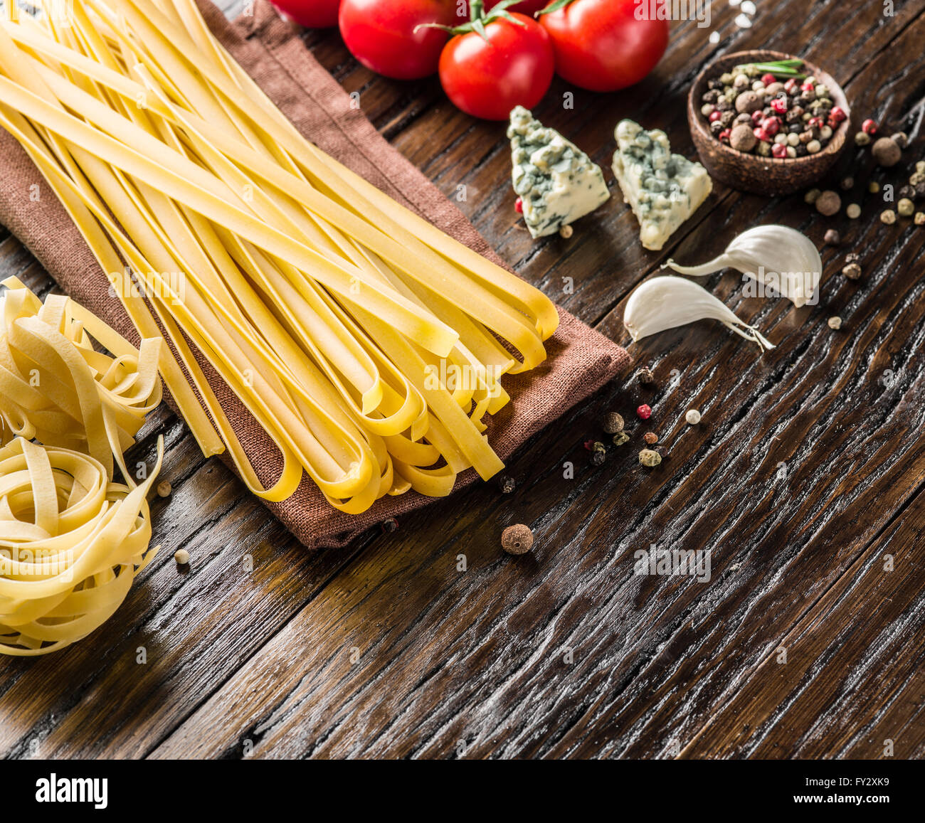 Ingredienti per la pasta. Cherry-pomodori, spaghetti e formaggio blu sul tavolo di legno. Foto Stock