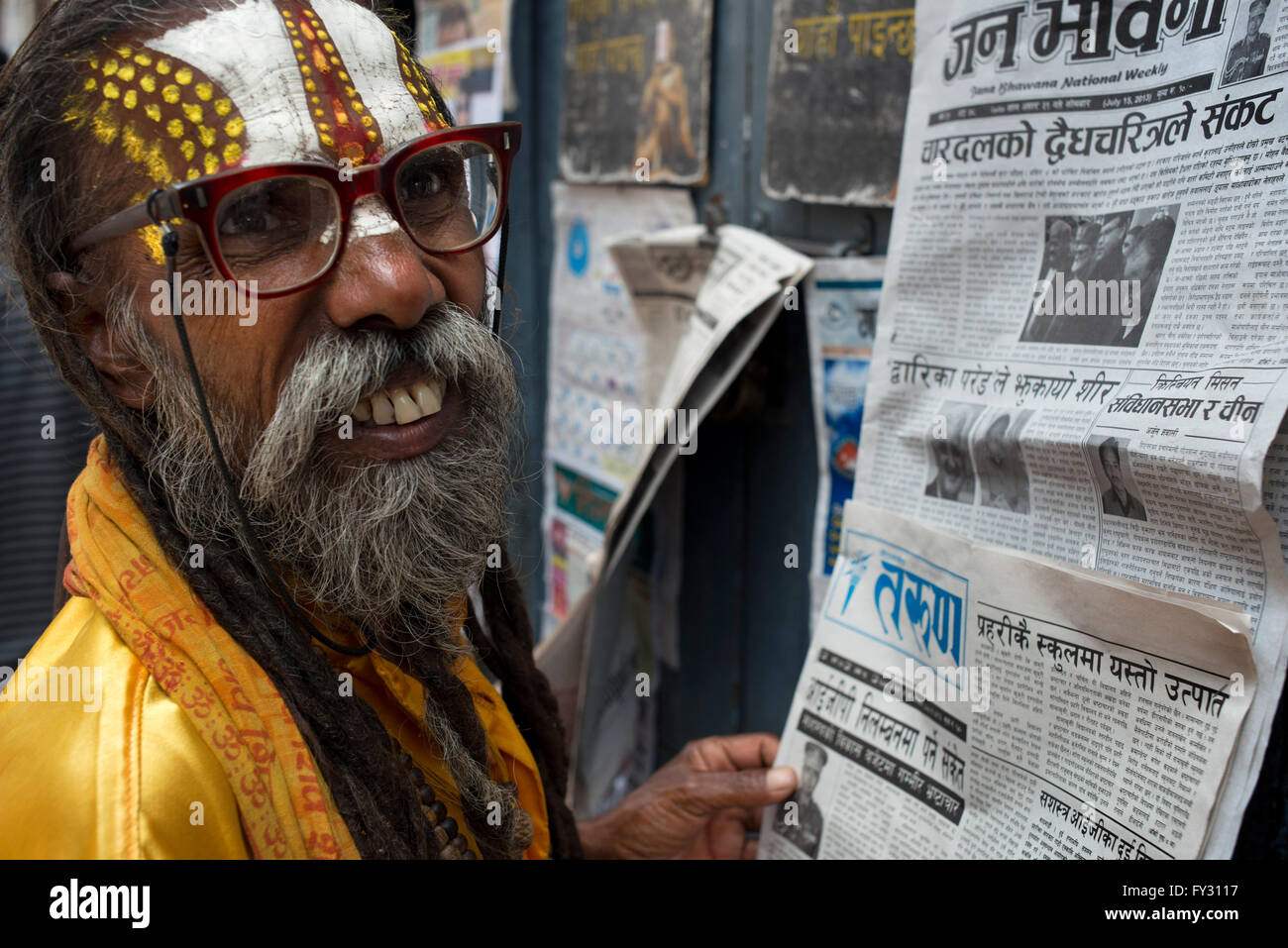 Indù nepalese uomo santo leggendo i giornali vicino a Basantapur, Kathmandu, Nepal Foto Stock