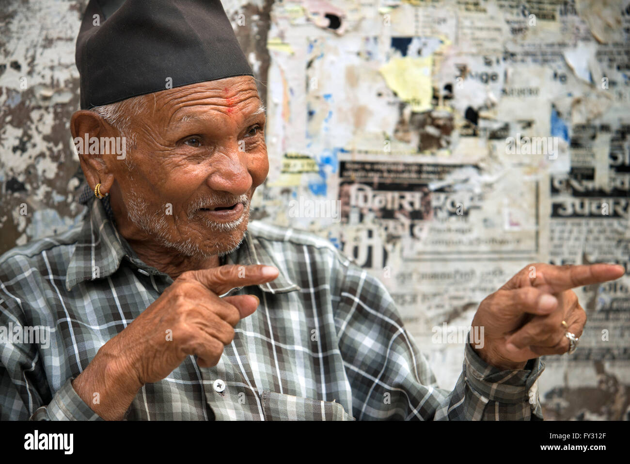 Vecchio nepalese uomo buddista, ritratto, felice e sorridente, con cappuccio, di fronte alla fotocamera, copia, spazio all'aperto, la luce del sole. Kathmandu, Nepal. Foto Stock