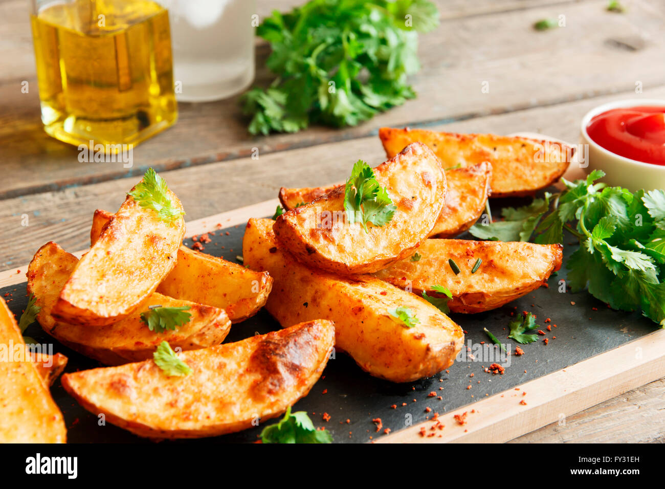 Cotto arrosto Spicchi di patate con erbe aromatiche Foto Stock