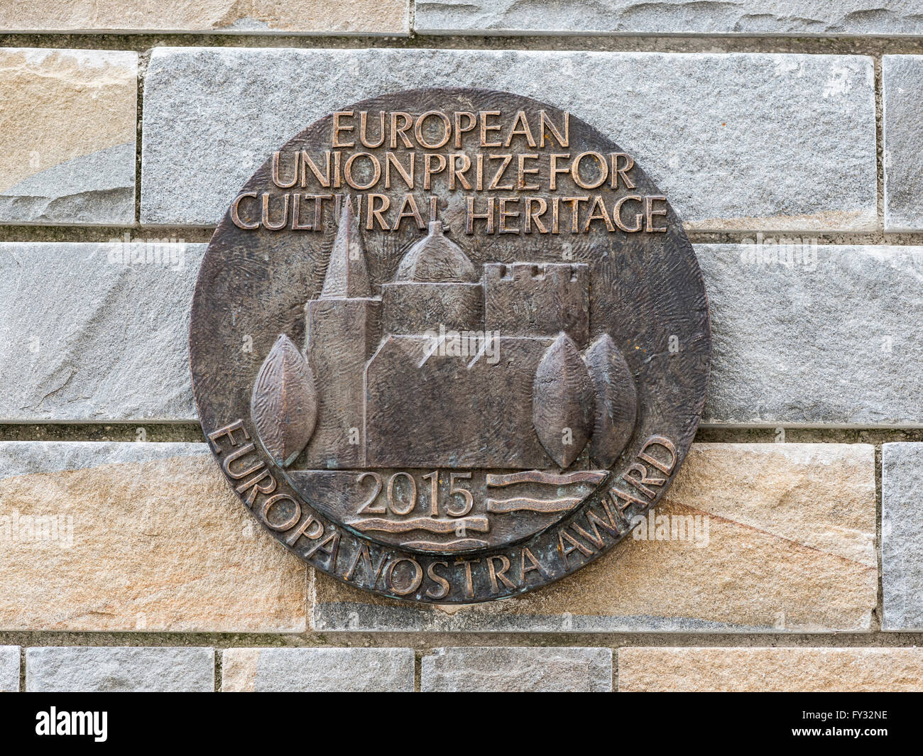 Medaglione di bronzo sul muro di pietra, il premio dell'Unione europea 2015 per servizi culturali e monumenti, Aquileia, Udine Foto Stock