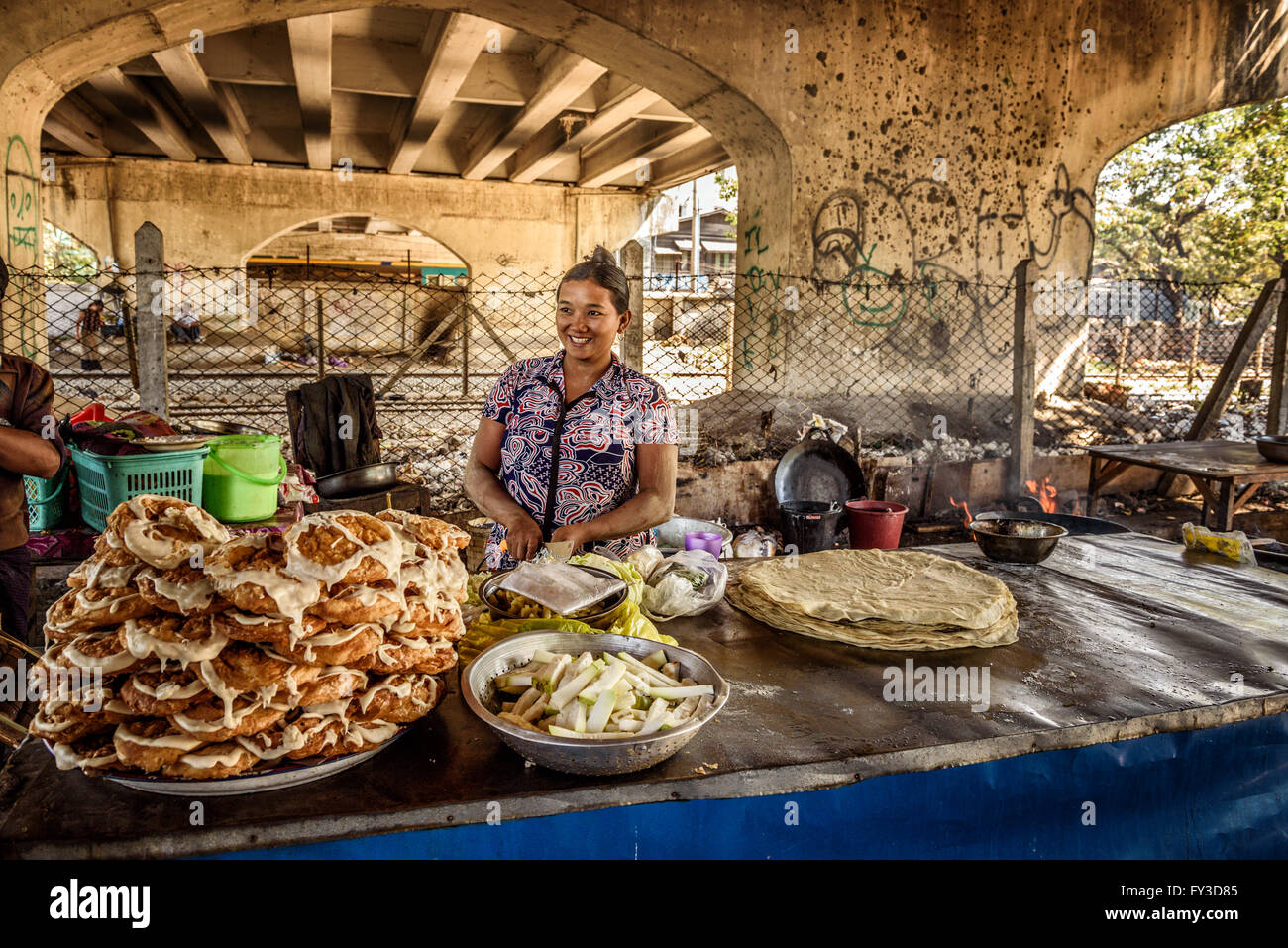 Donna cuochi e vende cibo di strada in Yangon. Foto Stock