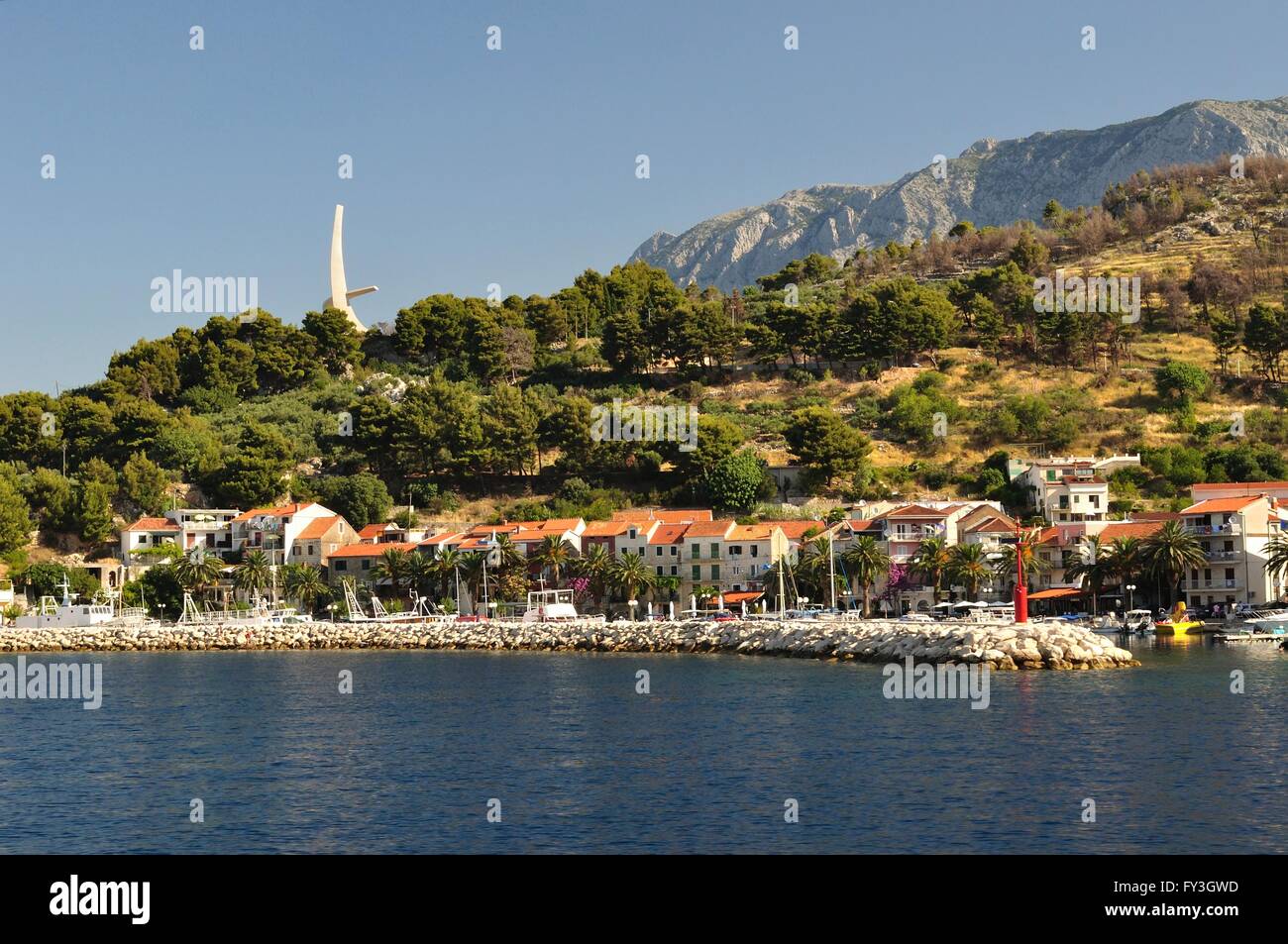 Mare adriatico a podgora in Croazia con il monumento di gabbiano ali e monte Biokovo in background Foto Stock