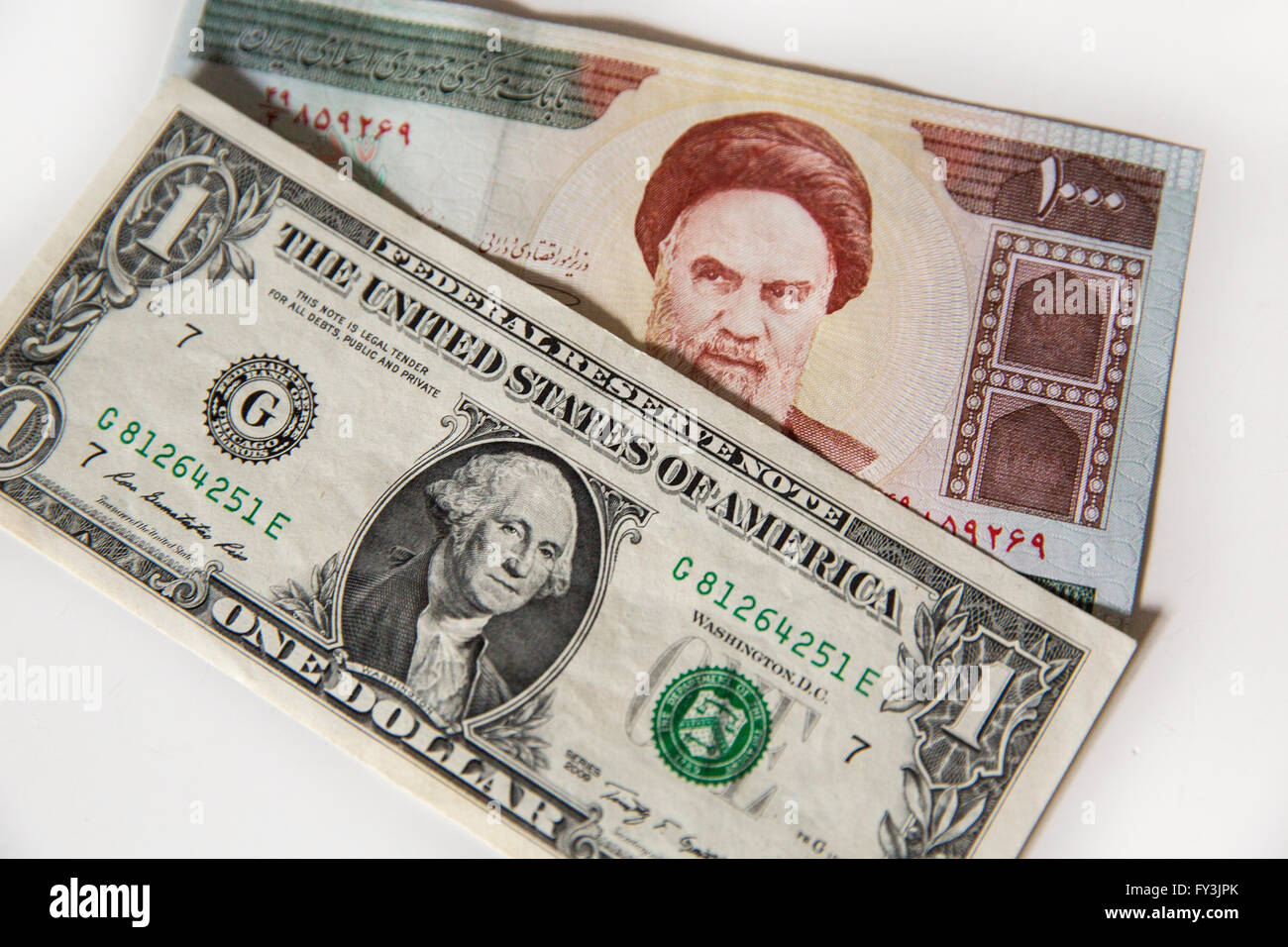 American un dollaro nota e un 1000 iraniano Rial nota giacente su un tavolo. Foto Stock