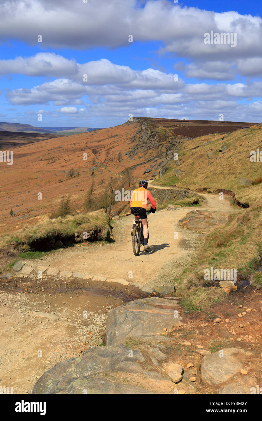 Ciclista voce verso il basso lungo la Causeway fuori bordo Stanage, Hope Valley, il Parco Nazionale di Peak District, Derbyshire, Inghilterra, Regno Unito. Foto Stock