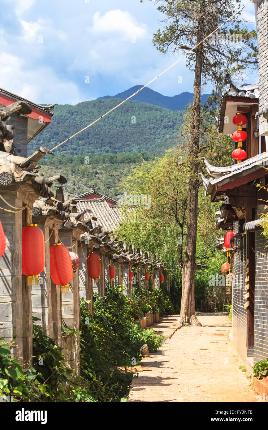Architettura tradizionale cinese e lanterne rosse nella parte anteriore del paesaggio di montagna nella provincia di Yunnan Foto Stock