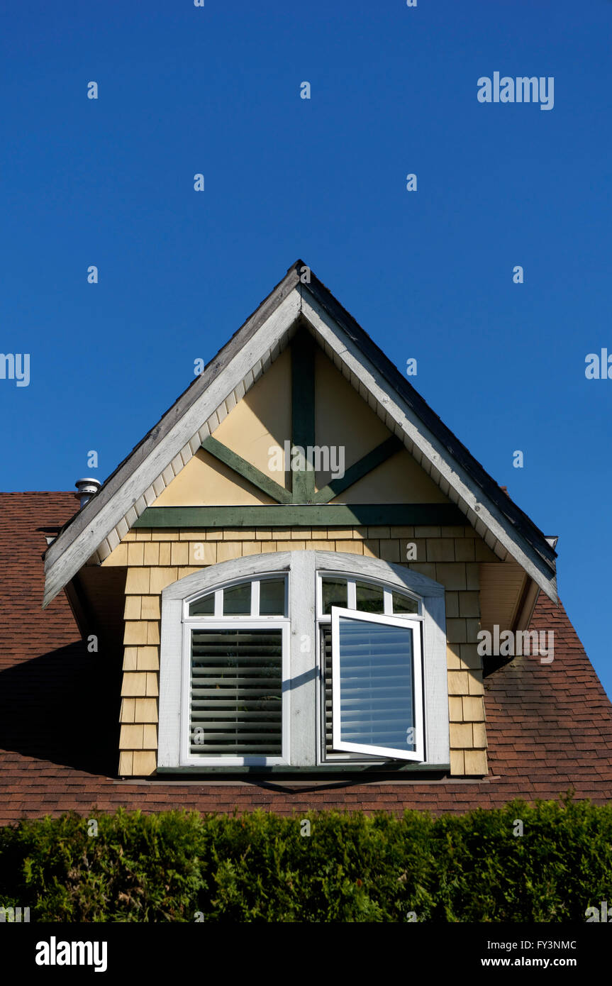 Finestra aperta sul tetto dell'anca in una casa di legno a Vancouver, BC, Canada Foto Stock