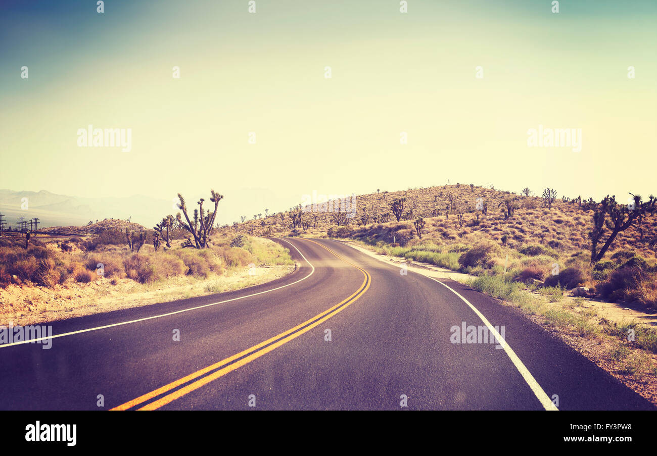 Vintage tonica strade del deserto visto attraverso il parabrezza di una vettura in movimento. Foto Stock