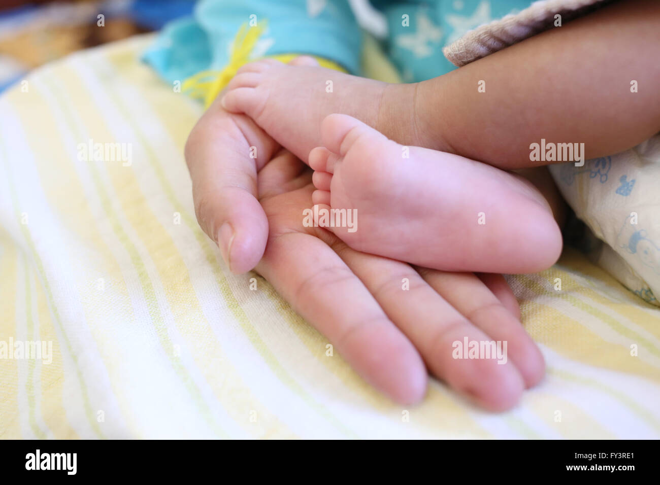 Piedi del bambino in mano mom all età di circa un mese. Foto Stock