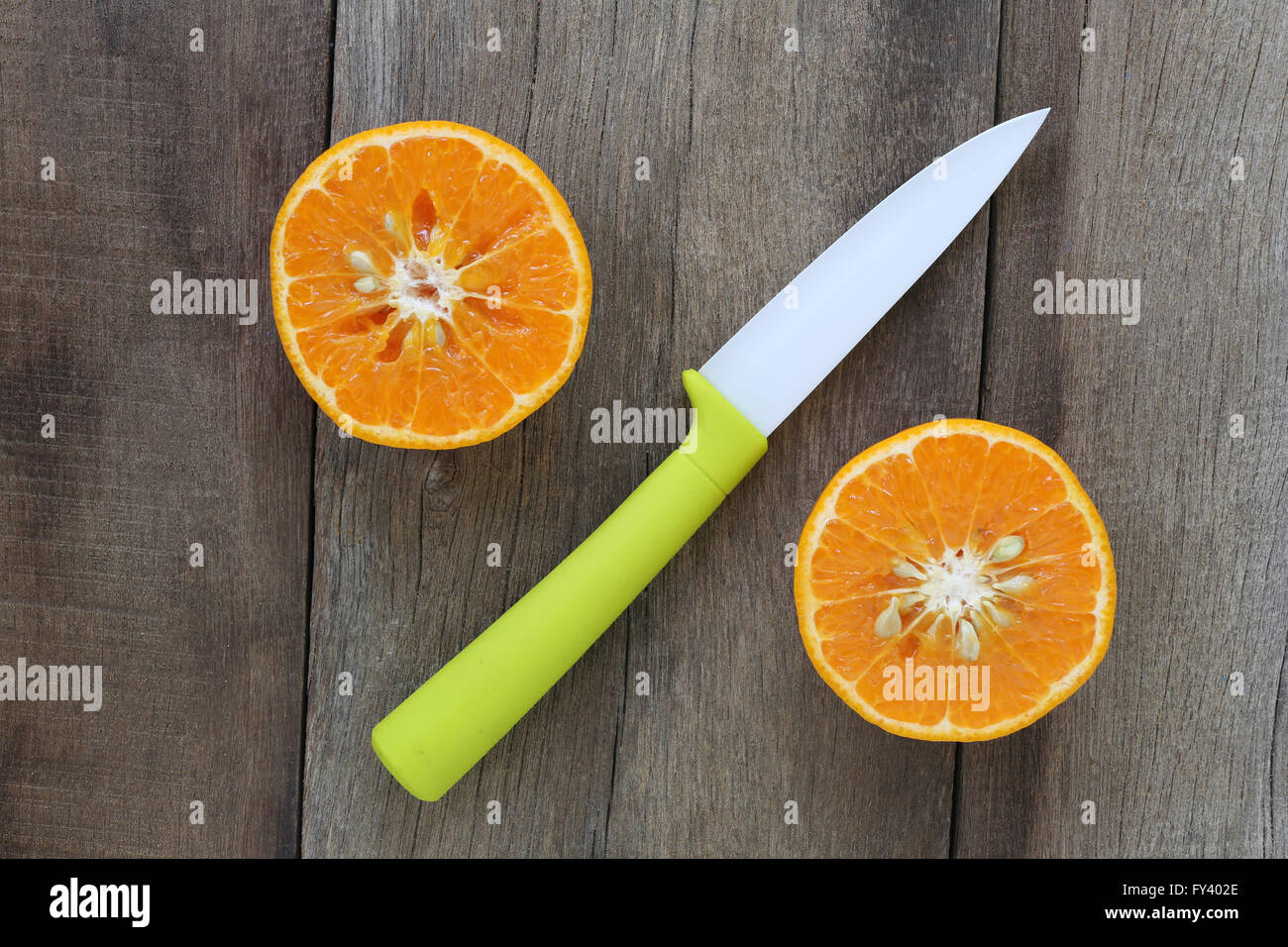 Mandarini arance e coltello acrilico posizionato sul vecchio pavimento in legno,design concept per circa health foods. Foto Stock