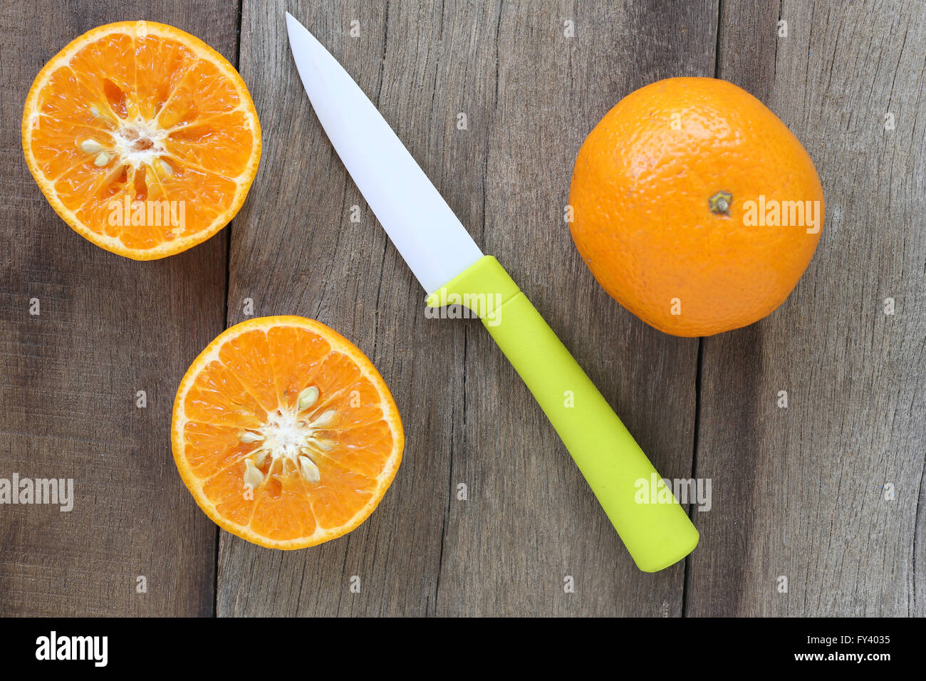 Mandarini arance e coltello acrilico posizionato sul vecchio pavimento in legno,design concept per circa health foods. Foto Stock