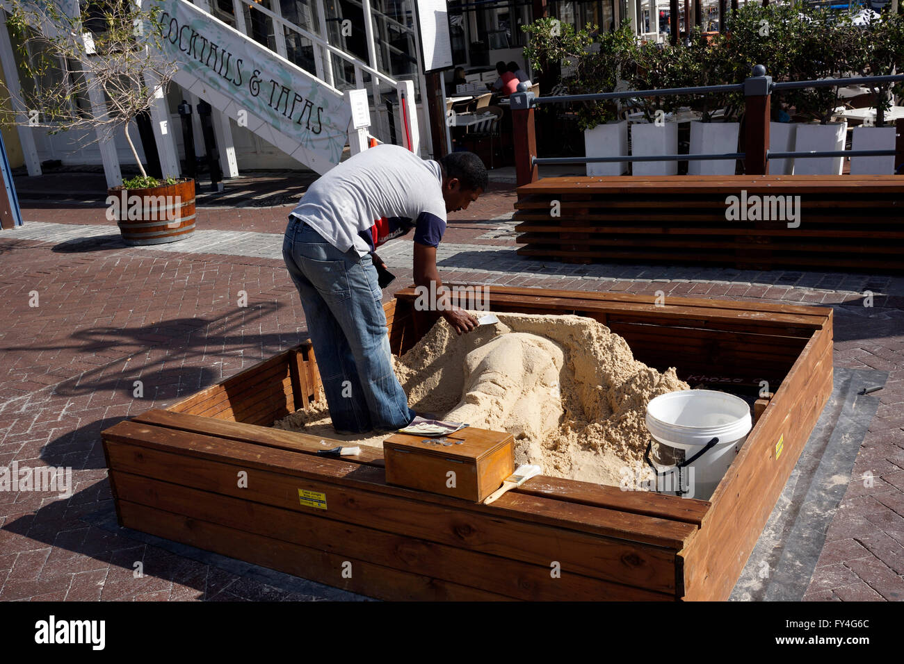 L'uomo scolpitura con sabbia per le donazioni al V & A Waterfront di Cape Town, Sud Africa. Foto Stock