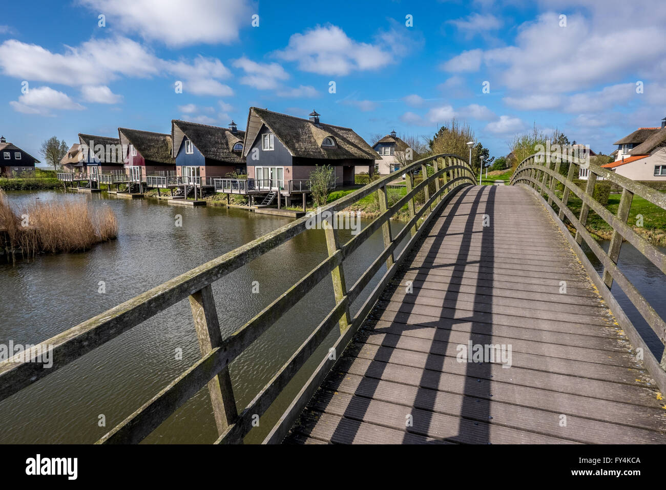 Un bel ponte archi attraverso un canale di Makkum holiday villiage in Frisia, Paesi Bassi. Foto Stock