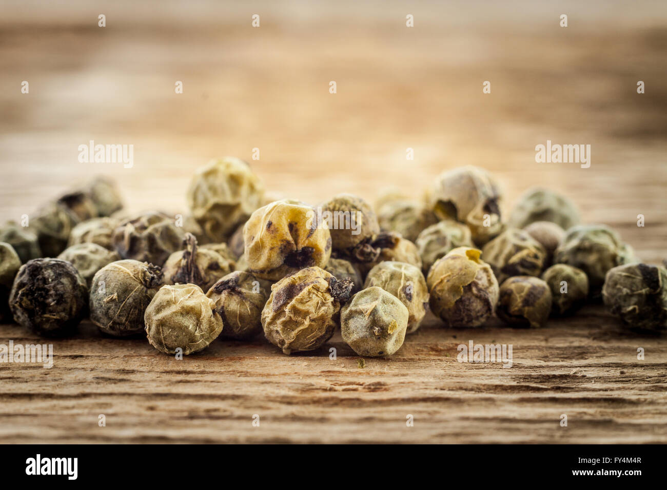 Asciugare peppe verde su sfondo di legno macro Foto Stock