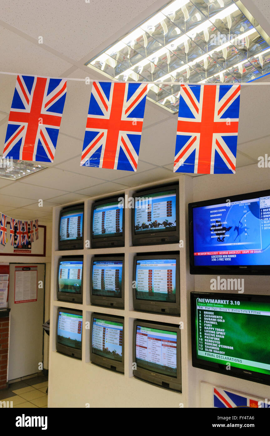 All'interno di un bookmaker con unione bandiera bunting davanti alla TV schermi televisivi e monitor Foto Stock