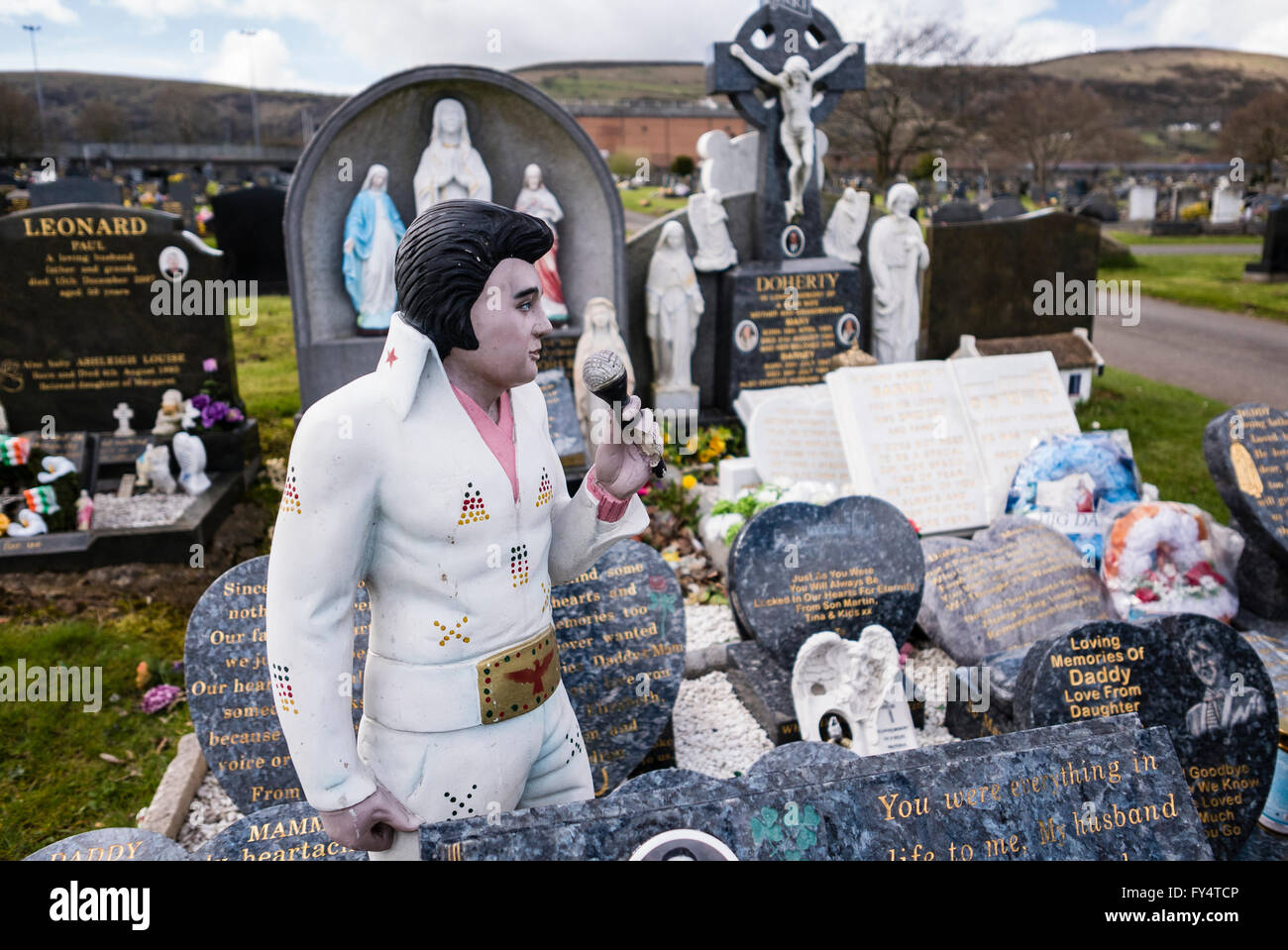 Un gran numero di marmo lapide su una tomba in un cimitero irlandese, tra cui una grande statua di Elvis Presley. Foto Stock