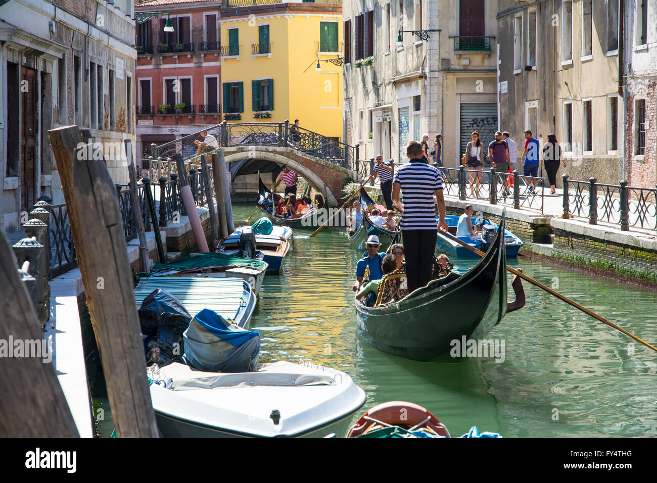Venezia,Italy-August 12,2014:gondolieri veneziani trasportare alcuni turisti su una gondola a Venezia durante una giornata di sole all'interno di lei Foto Stock