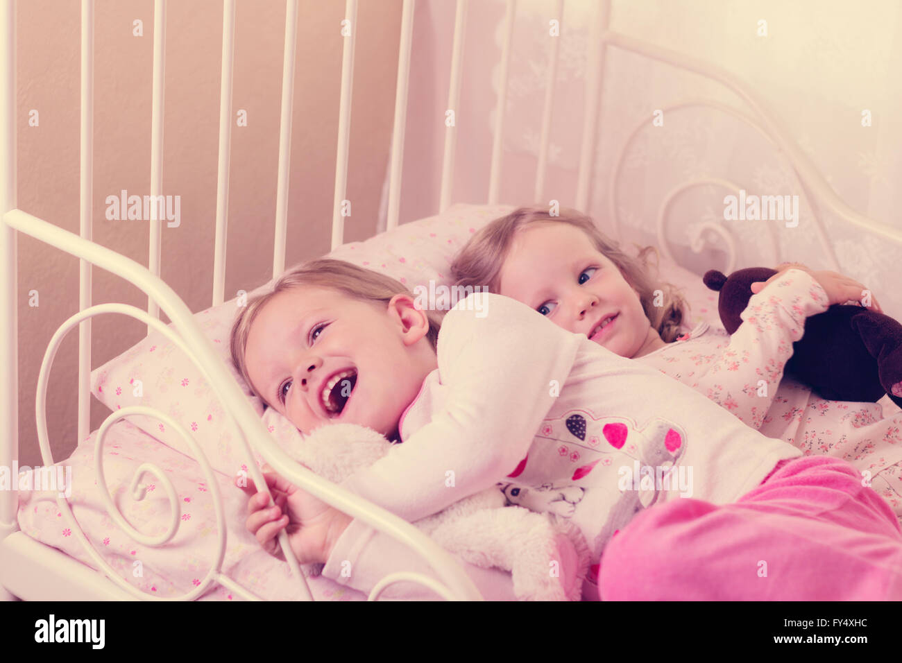 Little cute ragazze (suore) giocare nel letto. Messa a fuoco selettiva. Foto Stock