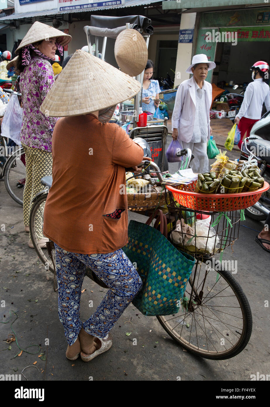 Vietnam Hanoi tradizionale mercato di strada donna con bicicletta che vende cibo di strada Foto Stock