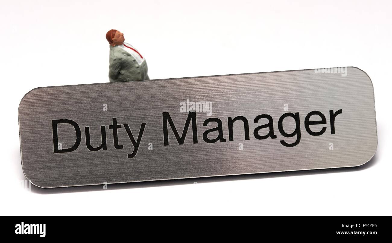 Duty manager il badge con una statuetta in miniatura uomo a camminare dietro di essa Foto Stock