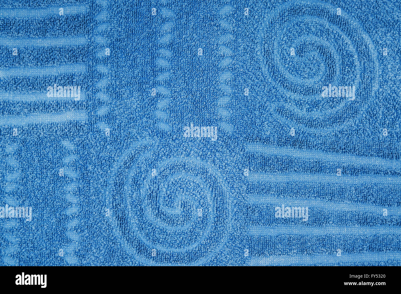 Close up di un ciano, blu, asciugamani in spugna con caratteristiche geometriche e modello a spirale, orizzontale Foto Stock