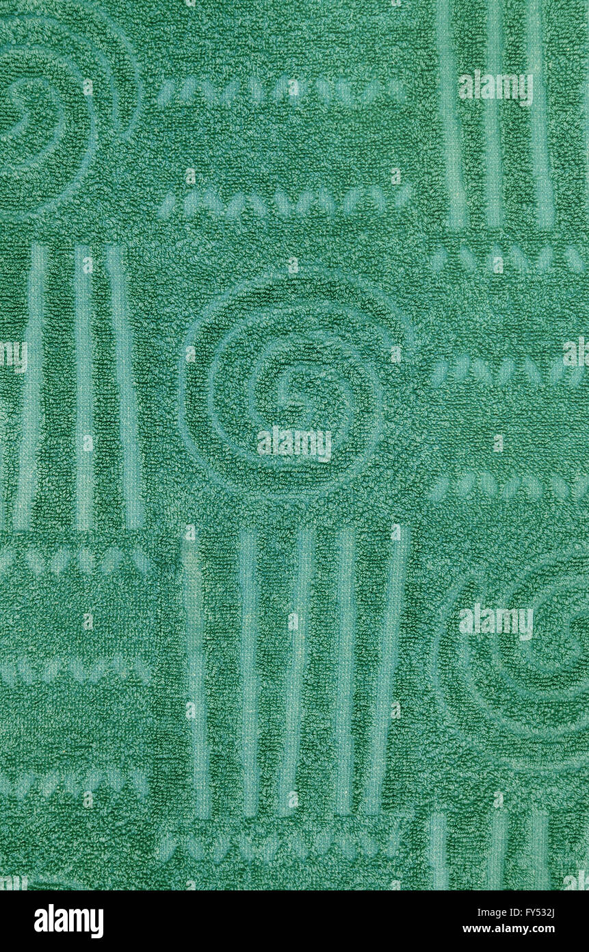 Close up di un verde asciugamani in spugna con caratteristiche geometriche e modello a spirale, verticale Foto Stock