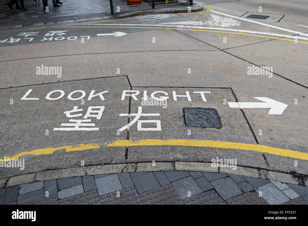 "Guardare a destra segno dipinto sulla strada in inglese e cinese, informando i pedoni da quale lato il traffico su strada è venuta. Foto Stock
