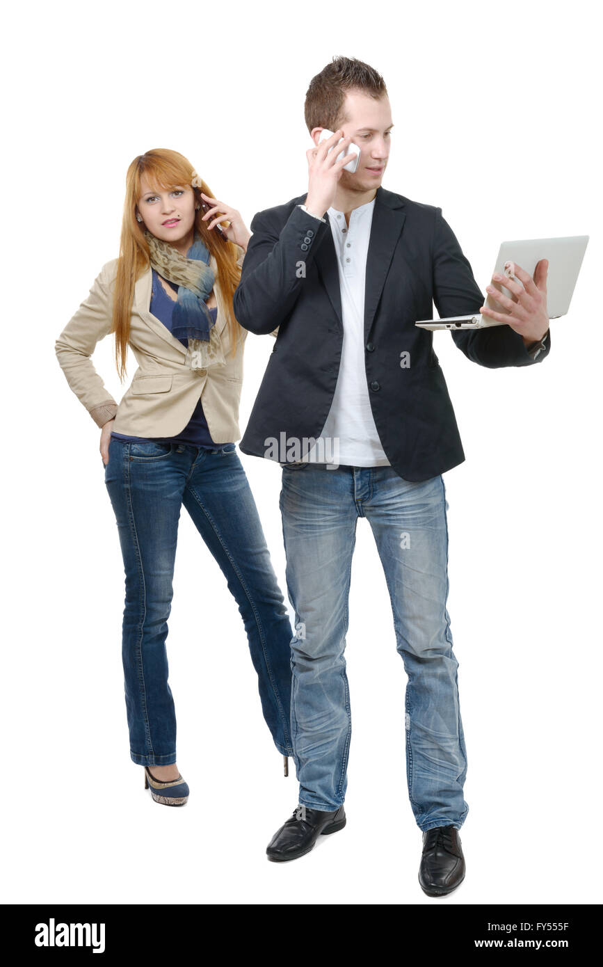 Due giovani uomini di affari che lavorando insieme con un computer portatile e telefono, su bianco Foto Stock