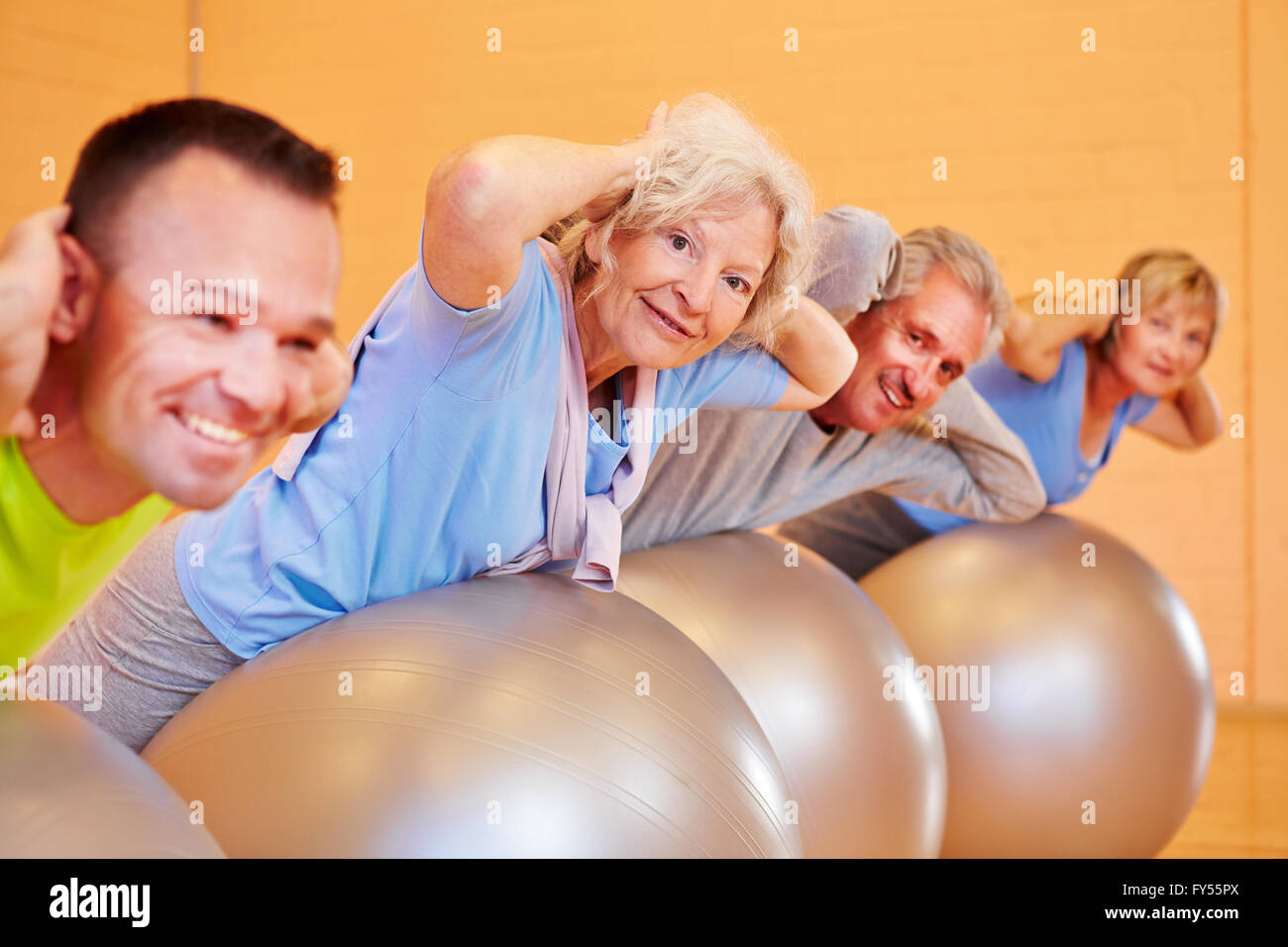 Gruppo di anziani facendo esercizi per la schiena in un centro fitness Foto Stock