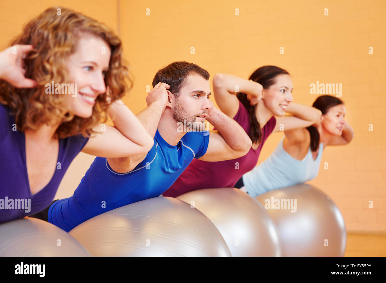Gruppo giovane facendo ginnastica in palestra palestra su sfere Foto Stock